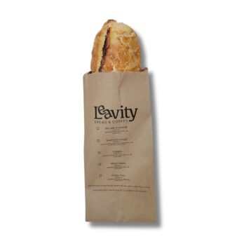 Photo of a paper bread bag with an artisan loaf sticking out.